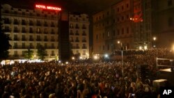 Warga menghadiri pidato Pablo Iglesias, pemimpin Partai Podemos (We Can) untuk merayakan hasil pemilu di Madrid (24/5). (AP/Daniel Ochoa de Olza)