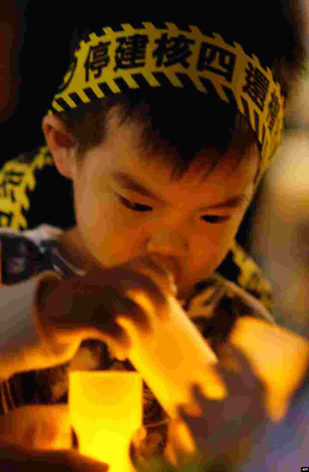 Seorang anak laki-laki Taiwan ikut berpartisipasi dalam demonstrasi untuk menolak pembangunan PLTN di Taipei, Taiwan.