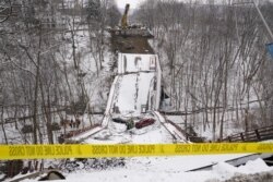 Beberapa kendaraan terlihat di atas sisa-sisa jembatan "Forbes Avenue" di atas Fern Hollow Creek yang ambruk hanya beberapa jam menjelang kunjungan Presiden AS Joe Biden kesana, di kota Pittsburgh, Pennsylvania, Jumat (28/1).