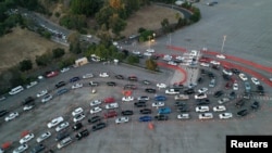 Magari yakiwa yamejipanga katika uwanja wa mpira Dodger wakazi zoezi la kupima COVID-19 likianza tena baada ya sikukuu ya Krismas huku wimbi jipya la maambukizi likirikodiwa Los Angeles, California, U.S. Disember 29, 2020. 