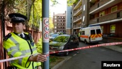 Polisi Inggris memblokir jalanan di Greenwich, saat penggeledehan sebuah apartemen terkait pembunuhan di Woolwich, London tenggara (23/5). 
