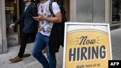 Ljudi prolaze pored restorana, sa znakom za zapošljavanje napolju, u Washingtonu, 5. oktobra 2023.