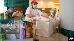 Një pizeri në Napoli duke përgatitur ushqimin për t'u marrë me vete jashtë restorantit (27 prill 2020)