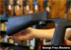 FILE - An example of a bump stock that attaches to a semi-automatic rifle to increase the firing rate is seen at Good Guys Gun Shop in Orem, Utah, U.S. on October 4, 2017.