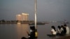 FILE - People uses their mobile phones on the Tonle Sap riverside in Phnom Penh, Cambodia, Feb. 18, 2021.