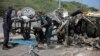 Somali soldiers check the wreckage of a car bomb outside the UN's office in Mogadishu, Somalia on July 26, 2016. 