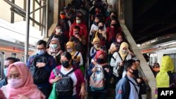 រូបឯកសារ៖ អ្នកដំណើរ​ពាក់ម៉ាស់​ដើរ​ទៅ​ជិះ​រថភ្លើង​នៅ​ស្ថានីយរថភ្លើងTanah Abang ក្នុង​ទីក្រុង​ហ្សាកាតា ប្រទេស​ឥណ្ឌូនេស៊ី ថ្ងៃទី១៨ ខែសីហា ឆ្នាំ២០២០។ 