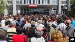 Warga setempat antri untuk memberikan suara dalam proses referendum di Mariupol, Ukraina (11/5). 