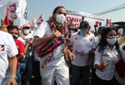 Popular Action party presidential candidate Yonhy Lescano dances while campaigning at the Caqueta market in Lima, Peru, April 5, 2021.