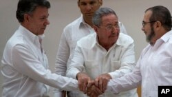FILE - Cuba's President Raul Castro (C) encourages Colombian President Juan Manuel Santos (L) and Commander the Revolutionary Armed Forces of Colombia or FARC, Timoleon Jimenez, to shake hands, in Havana, Cuba, Sept. 23, 2015.