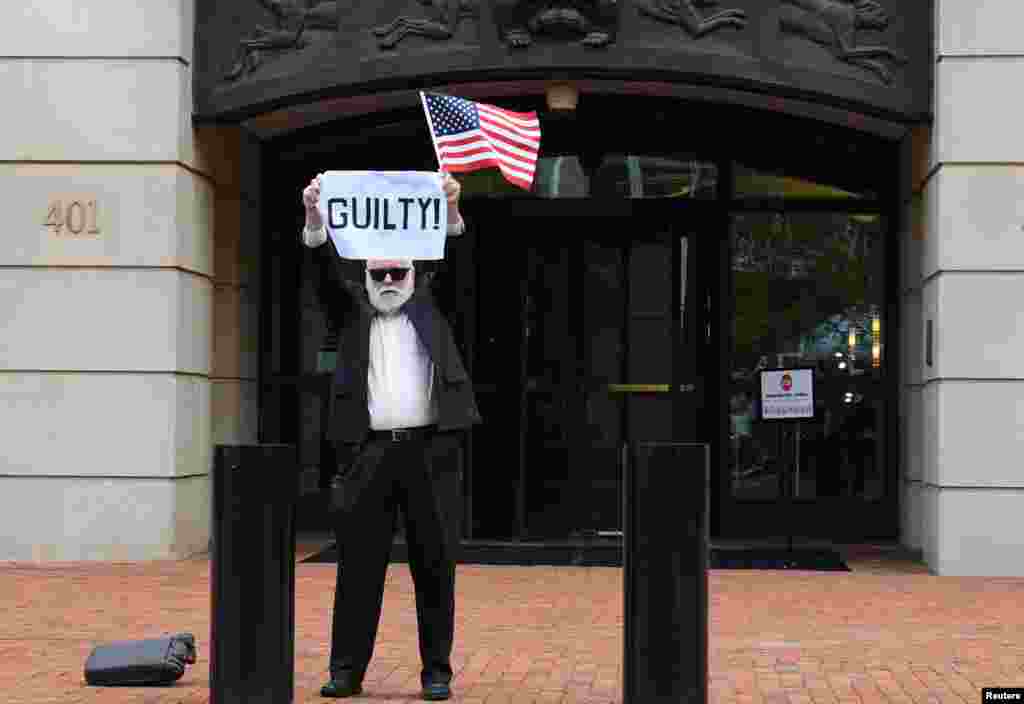 After a guilty verdict on the first count, an unidentified man holds a sign outside the U.S. District Courthouse in Alexandria, Virginia, Aug. 21, 2018, for the fourth day of jury deliberations in former Trump campaign manager Paul Manafort&#39;s trial on bank and tax fraud charges.
