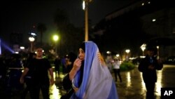 A woman protests the new measures announced to stop the spread of COVID-19, outside the government house in Buenos Aires, Argentina, April 9, 2021.