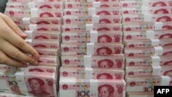 Seorang teller bank menghitung uang kertas yuan di sebuah bank di Lianyungang, provinsi Jiangsu, China, 11 Agustus 2015. 