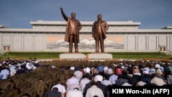 NORTH KOREA - People at Mansu Hill in Pyongyang bow before the statues of the late North Korean leaders Kim Il Sung and Kim Jong Il as the country marks the 25th death anniversary of Kim Il Sung, July 8, 2019