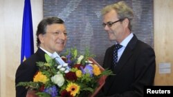 Presiden Komisi Eropa Jose Manuel Barroso (kiri) menerima rangkaian bunga dari Atle Leikvoll, Duta Besar Norwegia untuk Uni Eropa di Brussel (12/10). Uni Eropa memenangkan anugerah Nobel Perdamaian 2012.