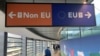 FILE - Passengers walk past a sign directing them to specific lines for EU and non-EU passports as they arrive at Dublin Airport in Ireland, Sept. 6, 2019.