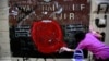 An anti-government protester volunteers to clean graffiti debris from the main gate of the Royal Thai Police Headquarters in Bangkok, Thailand, March 1, 2014. 
