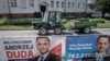 FILE - Election posters of incumbent Polish President Andrzej Duda, left, and Warsaw mayor and presidential candidate of the main Polish opposition party Civic Platform (PO) Rafal Trzaskowski hang on a fence in Leszno, Poland, July 6, 2020.