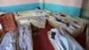 FILE - Bodies of civilians and security forces are placed at a hospital in Ghazni province, west of Kabul, Afghanistan, Aug. 12, 2018.