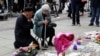 A Jewish woman named Renee Rachel Black and a Muslim man named Sadiq Patel react next to floral tributes in St Ann's Square in Manchester, May 24, 2017.