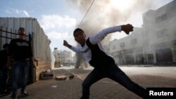 지난해 11월 요르단 서안지구 헤브론에서 팔레스타인 시위대 청년이 이스라엘 경찰을 향해 돌을 던지고 있다.