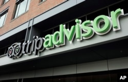FILE - The company logo for the travel website TripAdvisor hangs at the company's headquarters, Thursday, Nov. 2, 2017, in Needham, Mass. (AP Photo/Steven Senne)