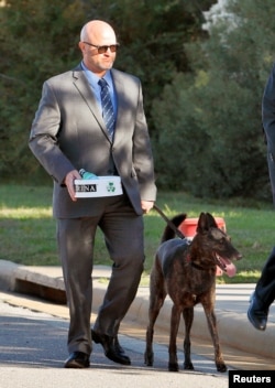 Former Navy SEAL James Hatch, shot in the leg during a July 2009 attempt to rescue U.S. Army Sergeant Bowe Bergdahl in Afghanistan, arrives with his service dog at the courthouse to testify on the second day of Bergdahl's sentencing proceedings at Fort Bragg, N.C., Oct. 25, 2017.