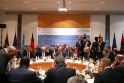 Members of the international committee take their seats for a follow-up meeting on Libya, arranged by German Foreign Minister Heiko Maas, in Munich, Germany, Feb. 16, 2020.