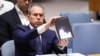 Israeli Ambassador to the UN Gilad Erdan shows a video of drones and missiles heading toward Israel during a United Nations Security Council meeting on the situation in the Middle Eas at UN headquarters in New York City on April 14, 2024. 