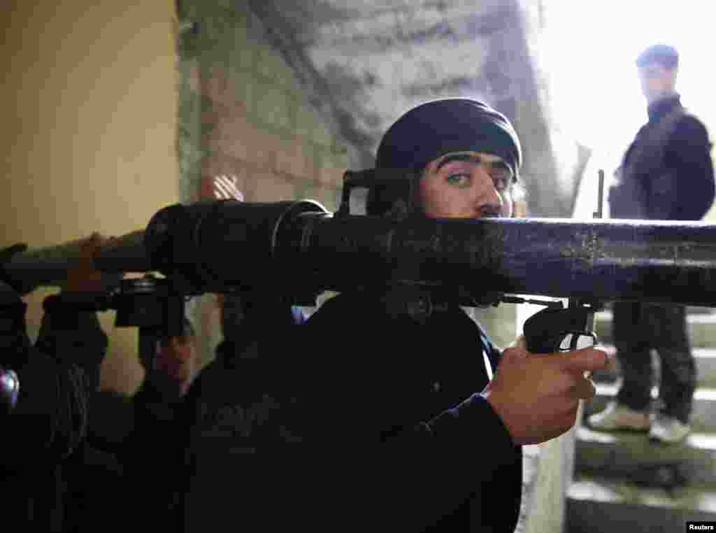 A Free Syrian Army fighter prepares to fire a B-10 recoilless gun in the Haresta neighborhood of Damascus, Feb. 7, 2013.