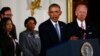 U.S. President Barack Obama stands with Vice President Joe Biden (R) and family members of shooting victims while delivering a statement on steps the administration is taking to reduce gun violence in the East Room of the White House in Washington, Jan. 5, 2016.