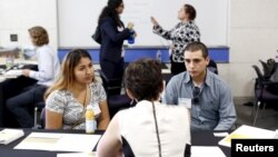 Job seekers work with recruiters at GRID Alternatives solar job fair in San Francisco, California July 15, 2015. The job fair featured 20 solar industry companies offering up to 200 open positions. 