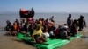 Rohingya refugees sit on a makeshift boat as they await permission from Border Guard Bangladesh to continue after crossing the Bangladesh-Myanmar border, at Shah Porir Dwip near Cox's Bazar, Bangladesh, Nov. 9, 2017. 