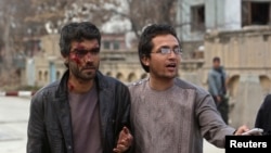 3月28日在喀布尔遭袭击的地点，一名男子在帮助一位在袭击中受了伤的人