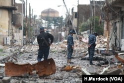Iraqi Federal police tour a neighborhood shortly after a battle, still littered with rubble and bodies of militants in Mosul, Iraq on March 16, 2017.