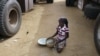 A girl gathers rice spilled from a humanitarian food convoy in the northeastern city of Gao, Mali, June 14, 2012.