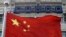 A Chinese national flag flies in front of COSCO's headquarters in Beijing Aug. 26, 2010. 