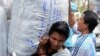 Laborers carry large bags of goods while working at a market in Bangkok. Thailand's new daily minimum wage hike to 300 baht ($9.8 USD) went into effect throughout the country on January 1, January 4, 2013.