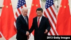 档案照：2013年12月4日，时任美国副总统拜登与中国国家主席习近平在北京人民大会堂握手。