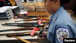 Una policía de Chicago prepara el inventario de armas entregadas por el público como parte de una campaña de desarme en esa ciudad.
