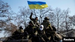 Anggota pasukan Ukraina dan kendaraan lapis baja berpatroli di dekat Debaltseve pasta penandatanganan kesepakatan gencatan senjata di Minsk (12/2).