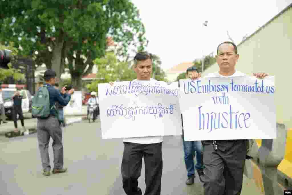 សន្តិសុខ​ដែល​ត្រូវ​បាន​ស្ថានទូត​សហរដ្ឋ​អាមេរិក​បញ្ឈប់​កាល​ពី​ប៉ុន្មាន​ខែ​មុន​​​និង​គ្រួសារ​របស់ពួកគេ​បាន​មក​ធ្វើ​បាតុកម្ម​តវ៉ា​រក​យុត្តិធម៌​ដោយ​អហិង្សា​នៅ​ខាង​មុខ​ស្ថានទូត​អាមេរិករាជធានី​ភ្នំពេញ​ ​កាល​ពីព្រឹក​ថ្ងៃទី​១៩ មិថុនា ឆ្នាំ ២០១៨។(ទុំ ម្លិះ/VOA)