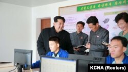 朝鲜中央通讯社发布的朝鲜领导人金正日在一个没有具体说明的日期里视察一家制鞋厂的照片。（2015年11月27日）