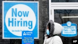 资料照片：一位女士走过伊利诺伊州绍姆堡一家清洗店的“现在招聘”标示。(2021年2月6日)