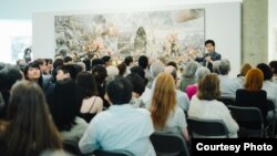 미국 워싱턴의 카젠미술관에서 큐레이터 문범강 교수가 북한화가 6명의 공동작품 '댐의 완공을 기쁨으로 기대하며'(2015년 작)를 관람객들에게 설명하고 있다. 사진 제공 = 노체인.