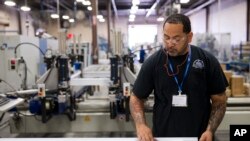 FILE - A worker assembles construction supplies at Northeast Building Products in Philadelphia, Aug. 28, 2014.
