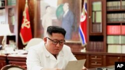 Shugaba Kim Jong Un yana karanta wasikar da Trum ya aika masa
