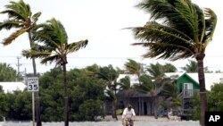 Seseorang mengendarai sepeda di kawasan Key West, Florida sementara angin bertiup kencang menjelang datangnya badai Isaac, Minggu (26/8). 