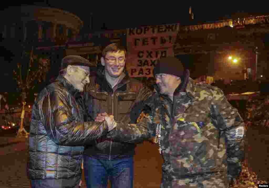 Russian former oil tycoon Mikhail Khodorkovsky (L) speaks with a member of the Maidan self-defense battalion as former Ukrainian Interior Minister Yuriy Lutsenko (C) looks on near a barricade in Kyiv, March 8, 2014. 