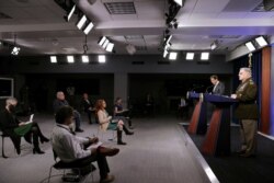 FILE - Members of the news media observe 'social distancing' as U.S. Defense Secretary Mark Esper and Joint Chiefs Chairman Army Gen. Mark Milley hold a news conference at the Pentagon in Arlington, Virginia, April 14, 2020.
